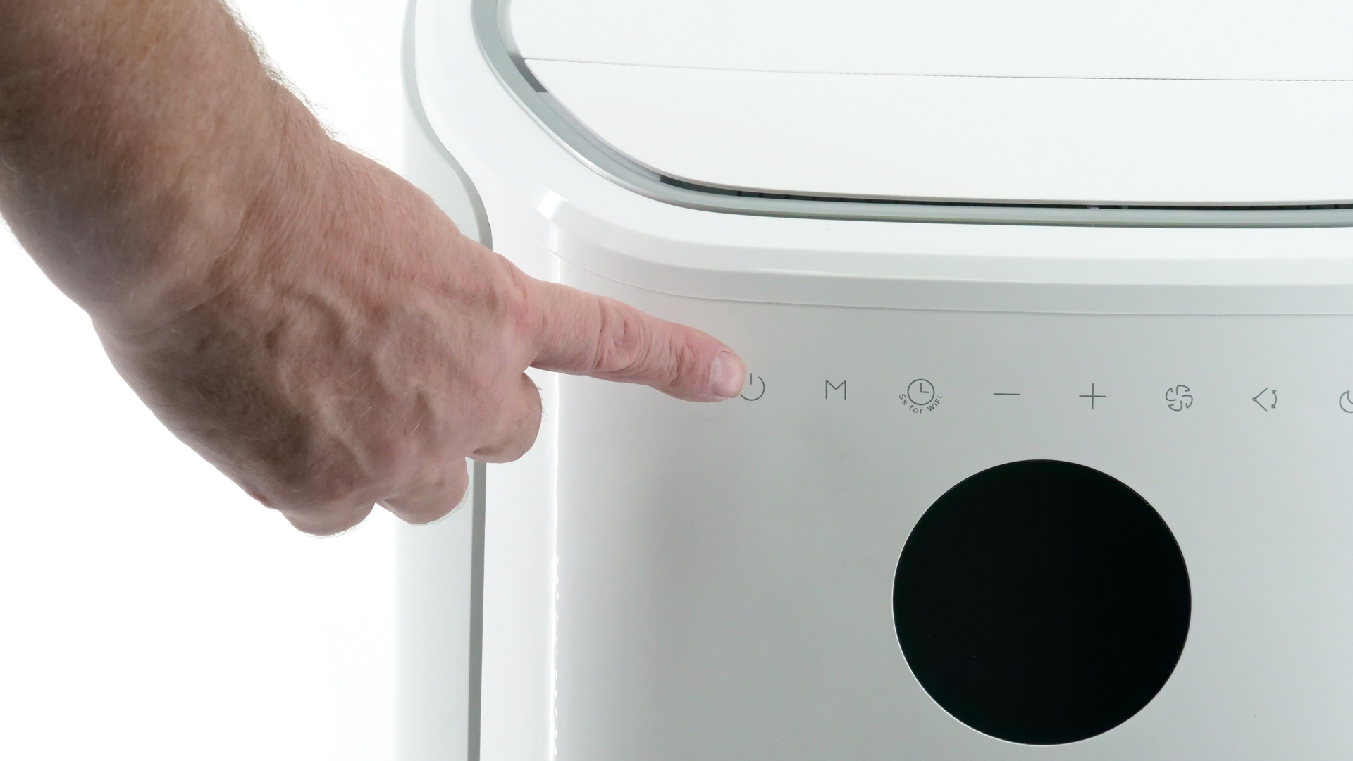 Ein Finger berührt eines der Symbole am Gehäuse des Modells.