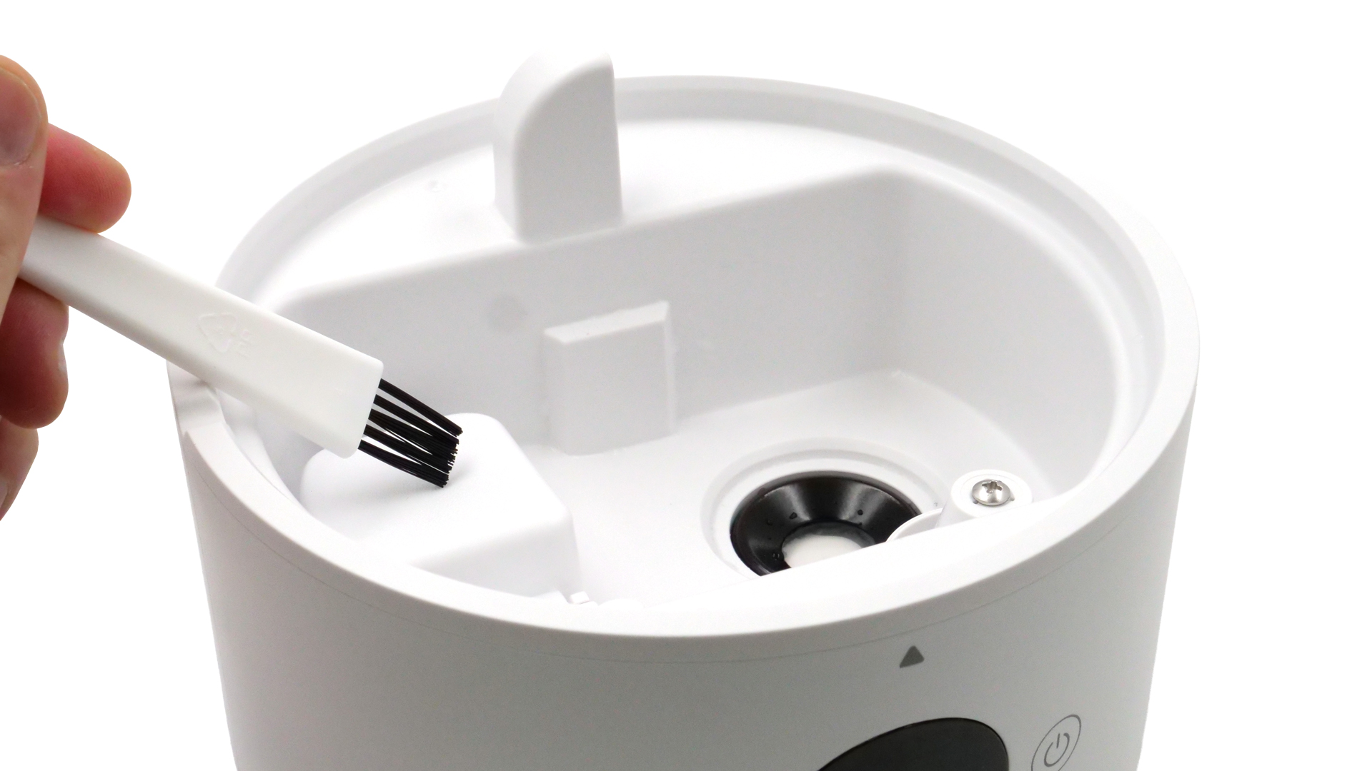 Eine Hand reinigt da Modell mit einem dünnen Pinsel.