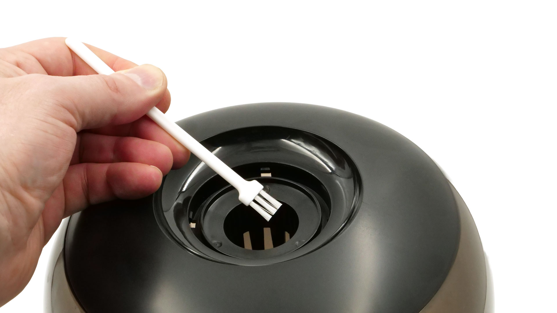 Eine Hand reinigt da Modell mit einem dünnen Pinsel.