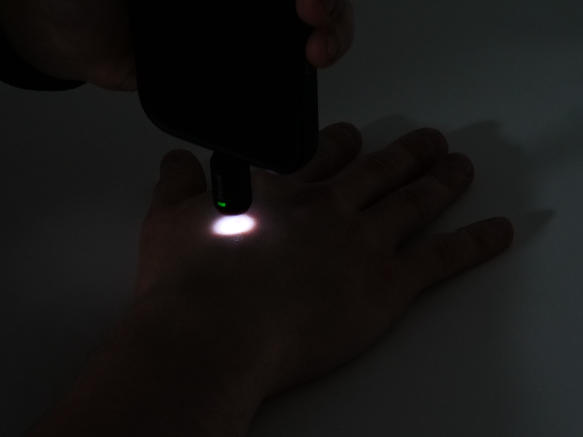 Handrücken bei abendlichen Lichtverhältnissen mit punktueller Beleuchtung des Beurer BiteX Go BR 70